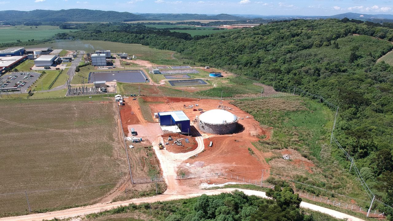 Vista aérea da planta de biogás com biodigestor e casa de máquinas